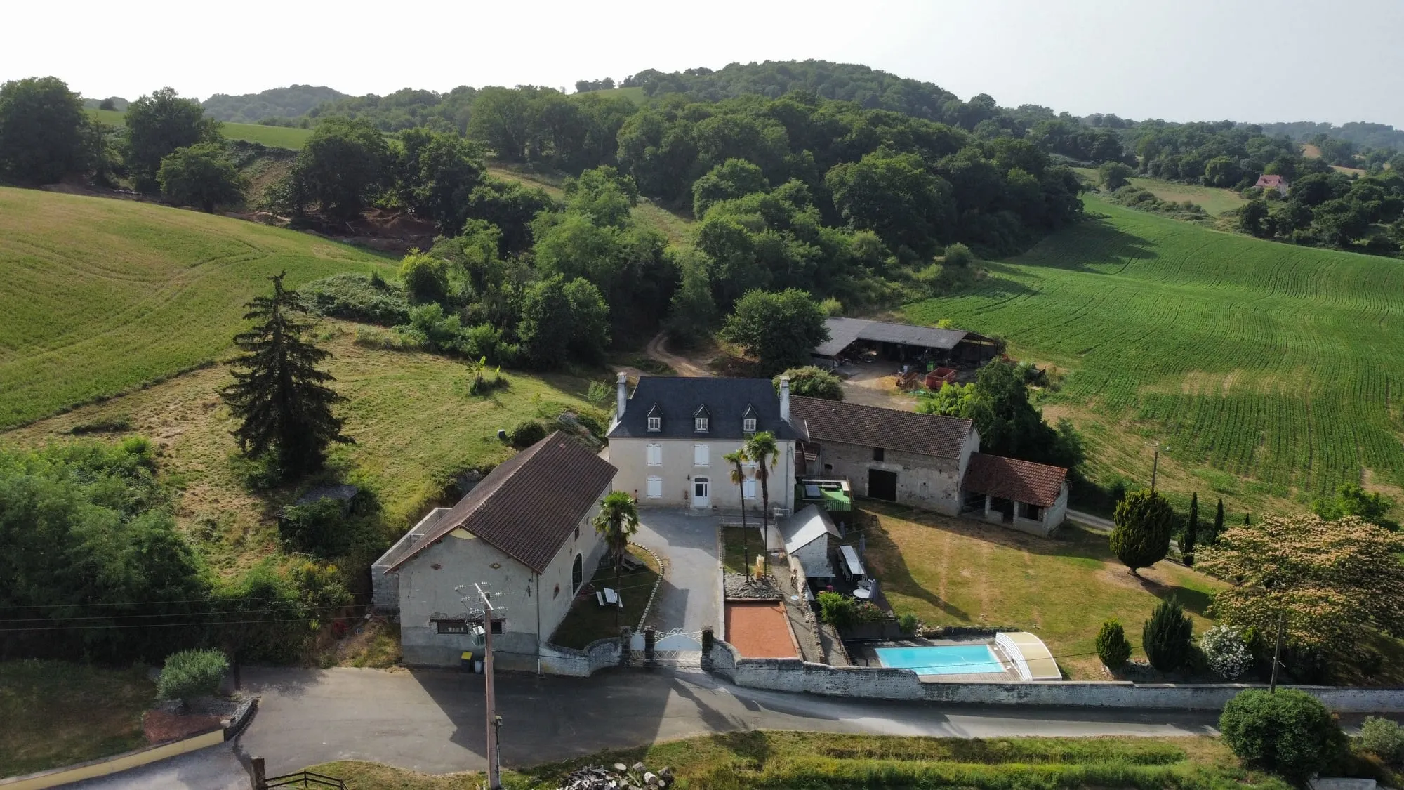 Le domaine vu du ciel, posé au creux des collines du Béarn, entouré de champs de maïs, de prés fauchés et de bois jusqu’à l’horizon