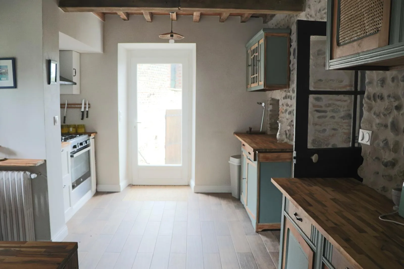 Cuisine traversante avec sa porte vitrée ouvrant sur la cour