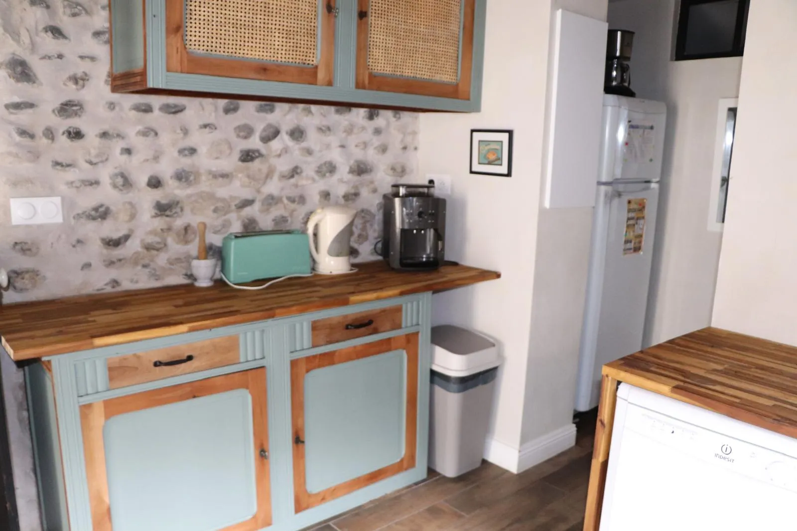 Coin cuisine avec réfrigérateur, lave-vaisselle et meubles à portes cannées